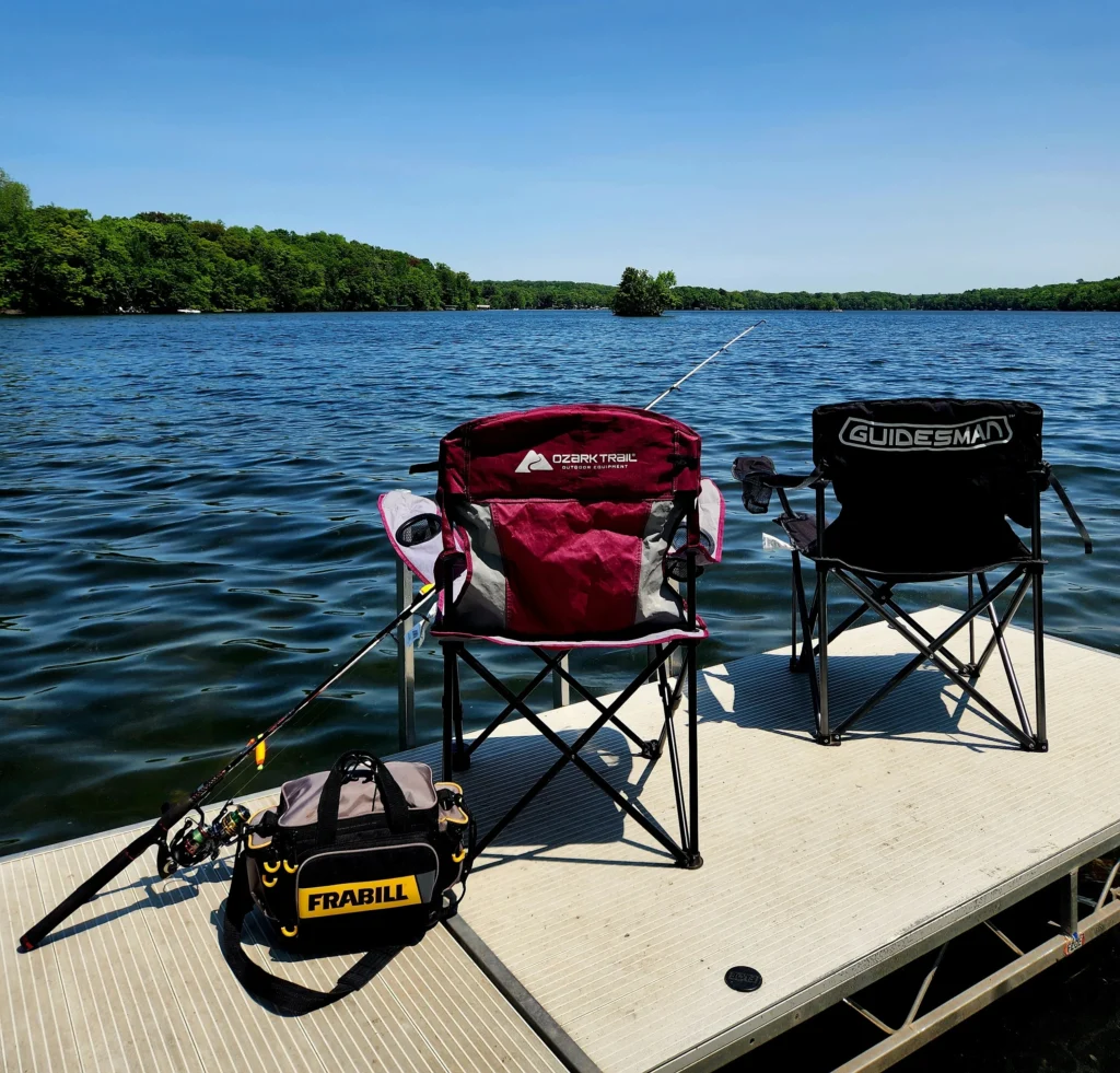 Two chairs and fishing poles on a lakeside cabin dock at Birch Lake on a sunny summer day.