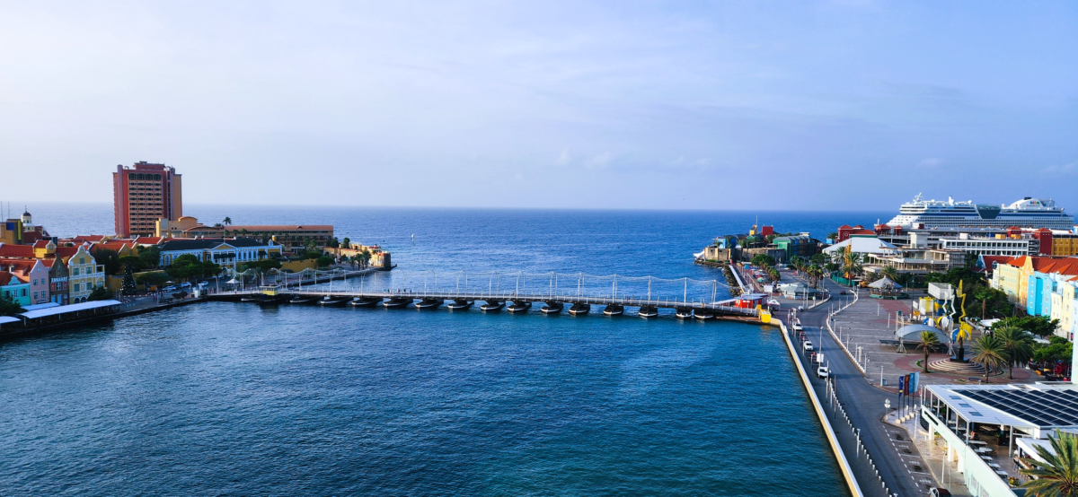 Curacao Cruise port floating bridge-.webp - Dohrn Travels Queen Emma Floating Bridge and colorful waterfront at Curaçao cruise port in Willemstad – iconic Caribbean island arrival. Holland America Southern Caribbean cruise
