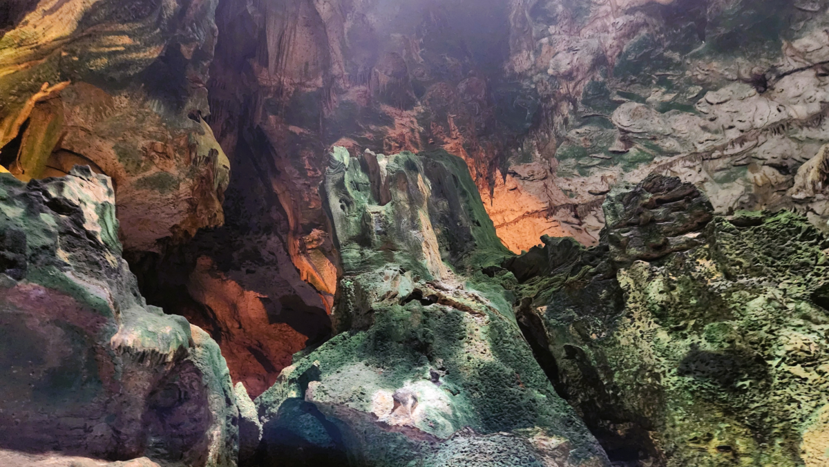 Interior view of Hato Caves in Curaçao with dramatic limestone formations and colorful lighting – popular Caribbean shore excursion