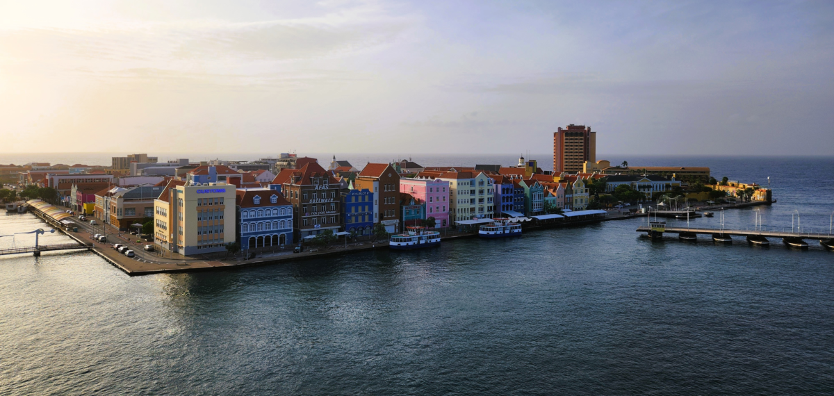 Colorful waterfront buildings and Queen Emma Bridge at Willemstad cruise port, Curaçao – iconic Caribbean island arrival view