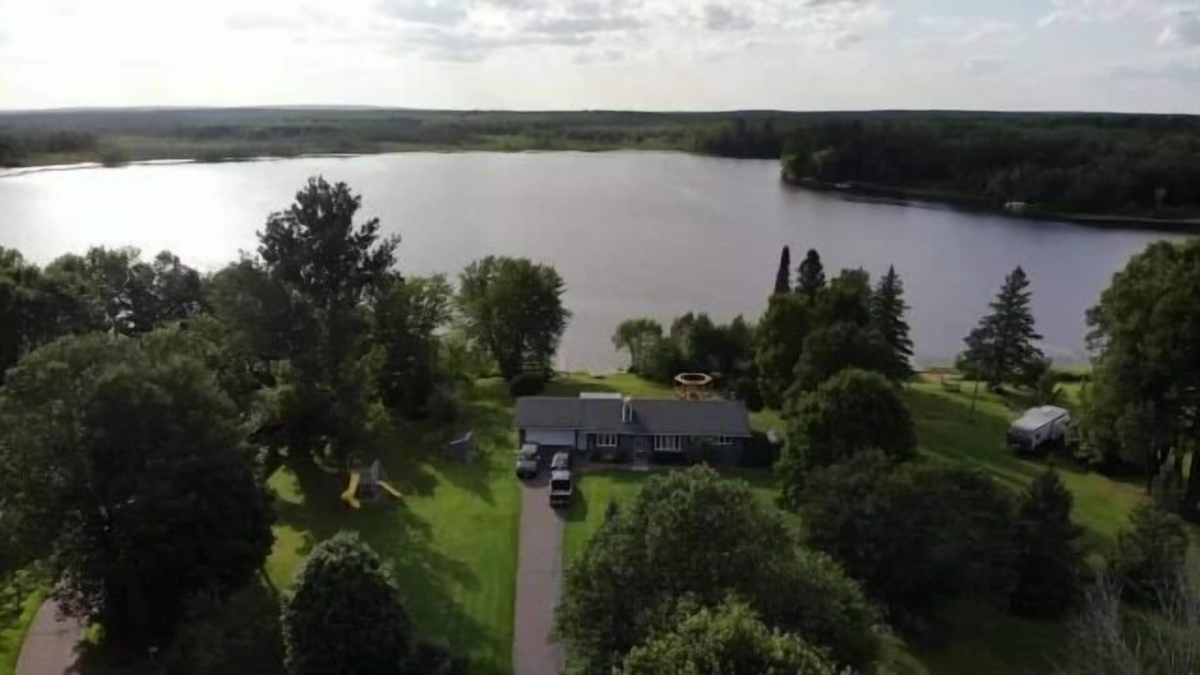 Aerial view of 5-bedroom lakefront cabin on Barber Lake near Winter, Wisconsin surrounded by trees and shoreline