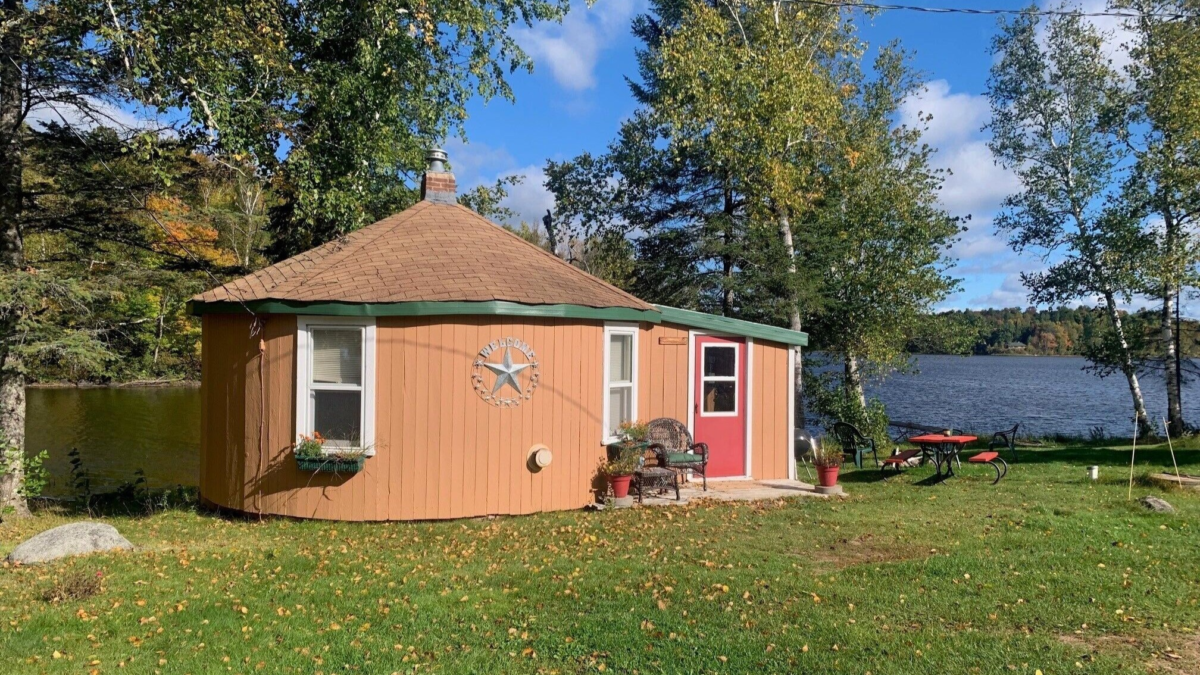 Round lakeside cabin at Bucktail Lodge on Barker Lake near Winter, Wisconsin with outdoor seating and water views