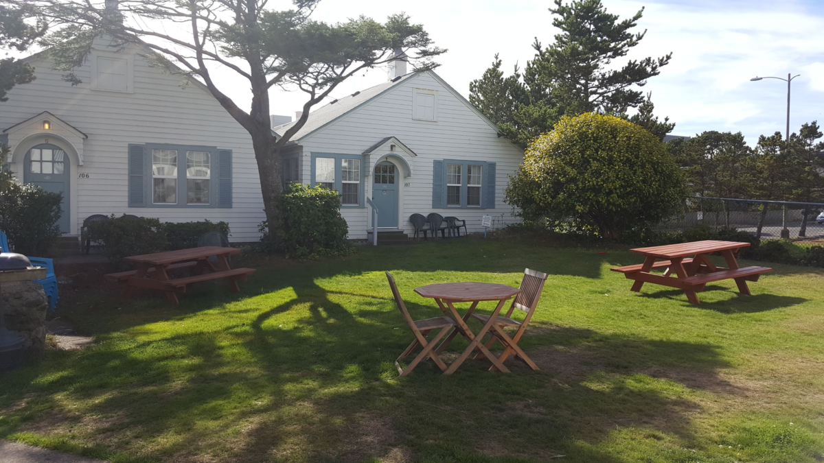 Hillcrest Inn cottages in Seaside Oregon with picnic tables and grassy courtyard — classic Oregon Coast lodging