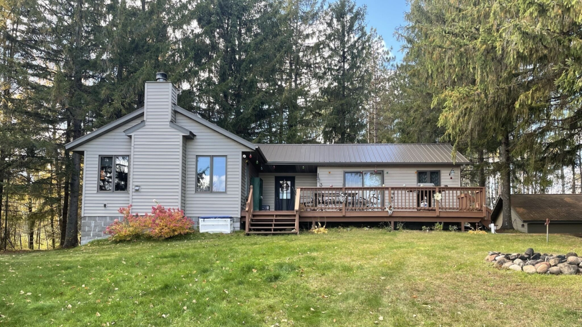 Pet-friendly lakefront cabin near Winter, Wisconsin with deck and firepit surrounded by pine trees
