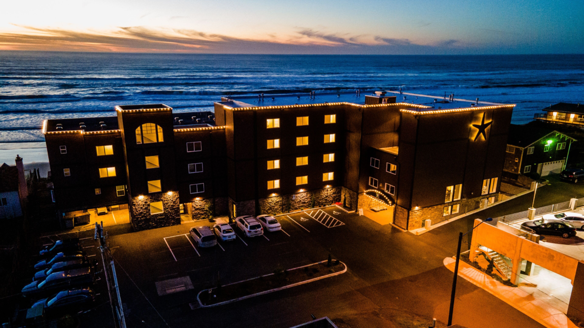 Starfish Manor Oceanfront Hotel in Lincoln City Oregon illuminated at sunset with oceanfront views