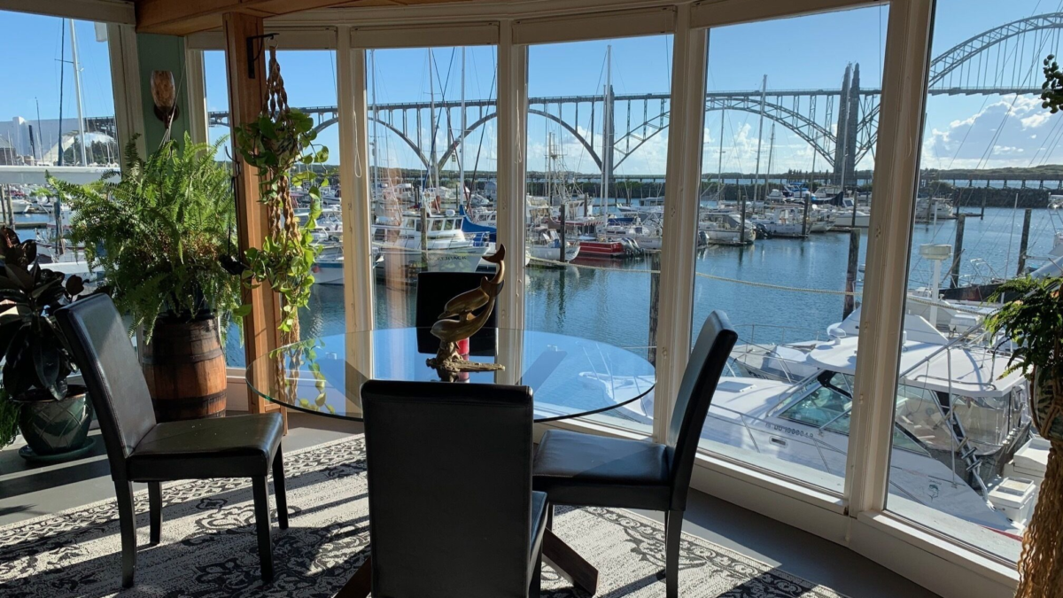 Waterfront dining area aboard The Newport Belle in Newport Oregon overlooking Yaquina Bay Bridge and marina