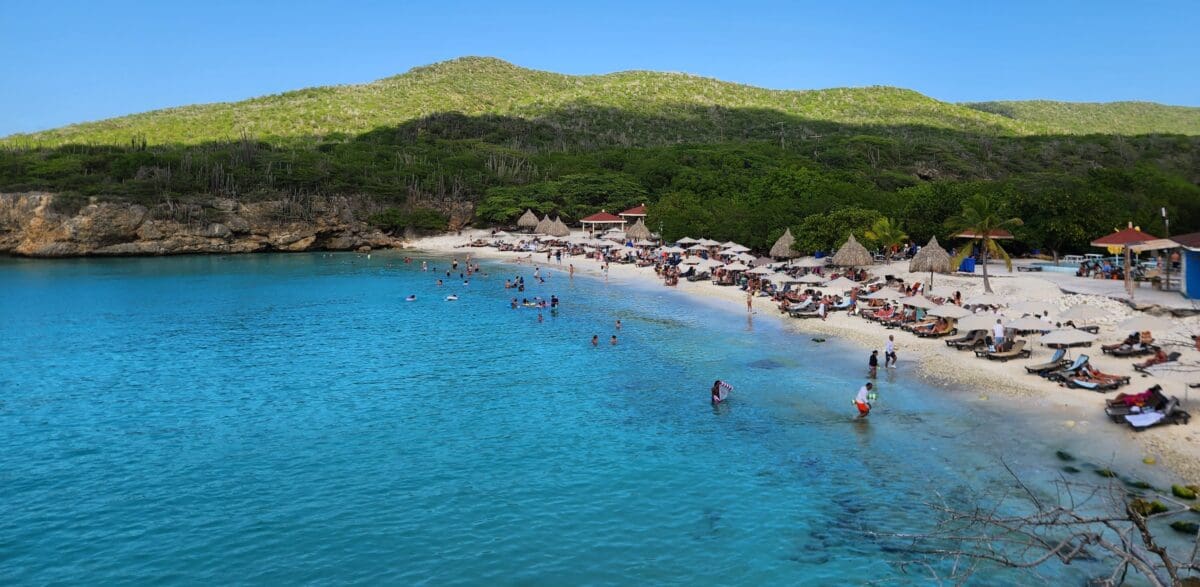 Grote Knip Beach Curaçao Panoramic View | Dohrn Travels Panoramic view of Grote Knip Beach in Curaçao with turquoise water and beach umbrellas
