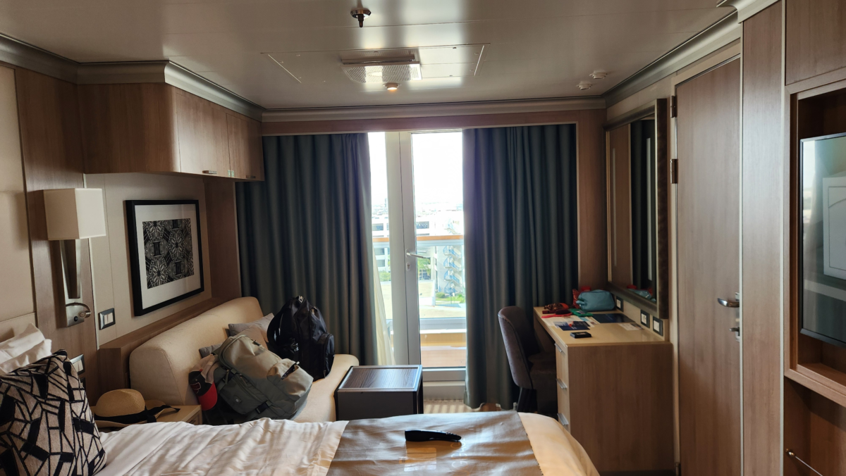 Holland America Rotterdam Verandah Cabin Interior - Dohrn Travels Holland America Rotterdam Verandah cabin with balcony door, sofa, and desk area. Holland America Rotterdam ship review