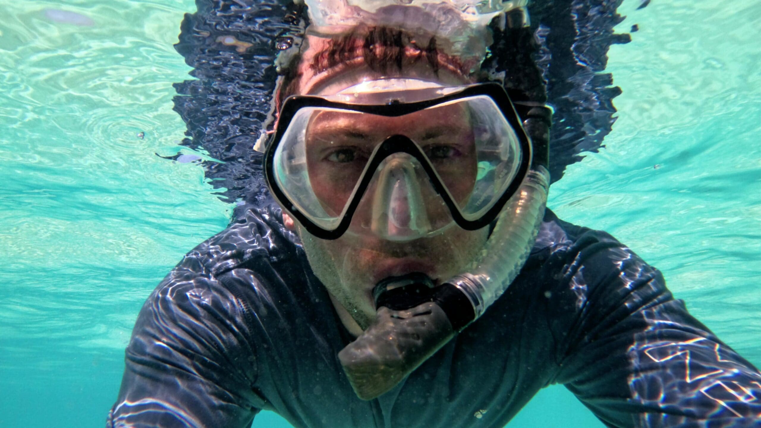 Snorkeling at Grote Knip Beach in Curaçao with clear turquoise water and rocky reef