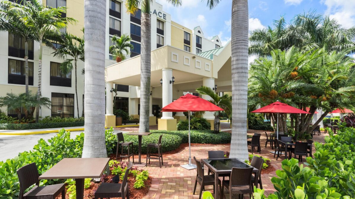 Hyatt Place Fort Lauderdale Cruise Port hotel patio near Port Everglades with outdoor seating and palm trees
