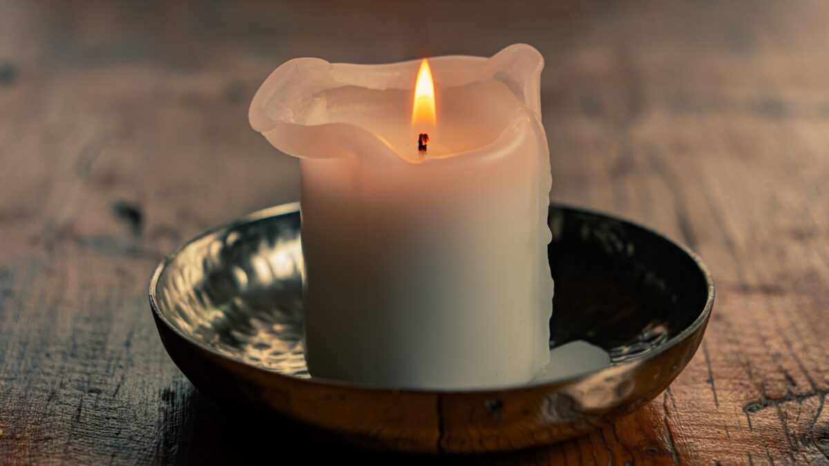 Lit candle on a wooden surface — candles are prohibited items on cruise ships and should not be packed for a Caribbean cruise