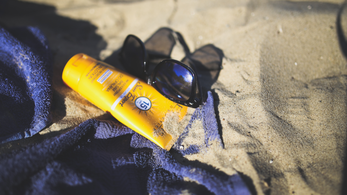 reef safe sunscreen and sunglasses on beach for cruise packing list sun protection essentials
