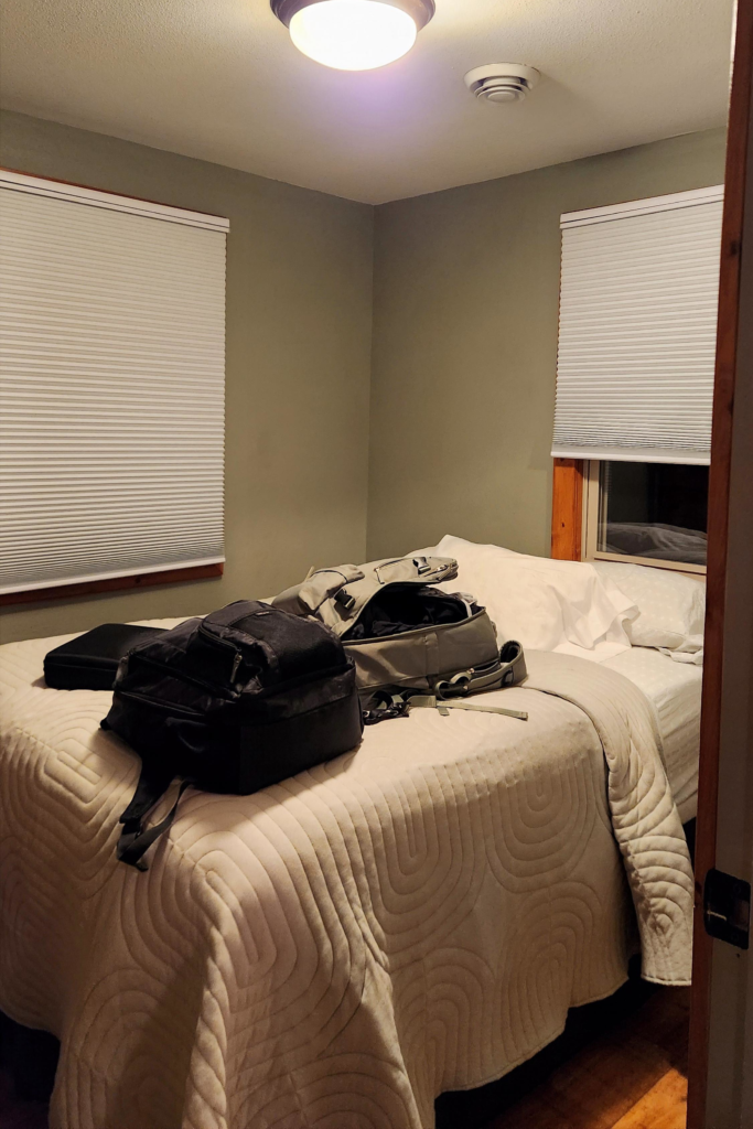Small bedroom inside Eagle Roost Resort cabin with queen bed and travel bags