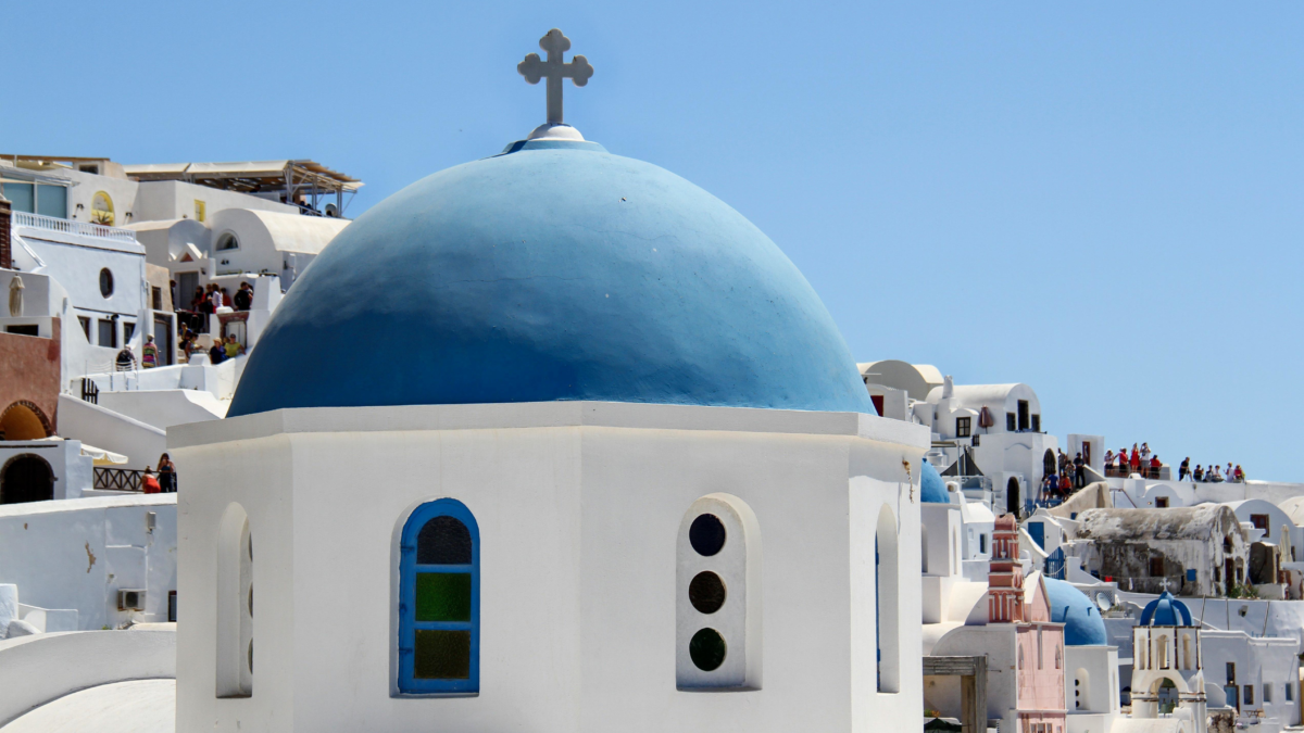 Blue domed church in Santorini Greece — Mediterranean cruise port with religious sites requiring covered shoulders and knees