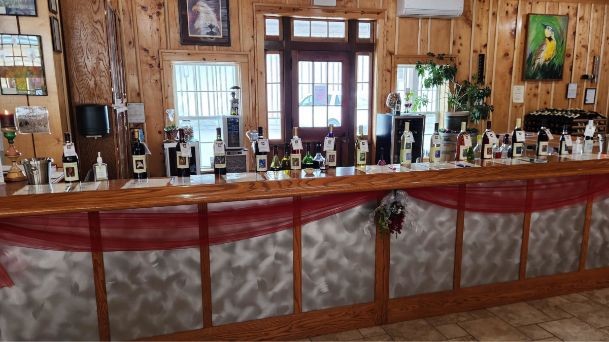 Wine tasting bar inside Whispering Bluffs Winery Wisconsin with bottles lined up