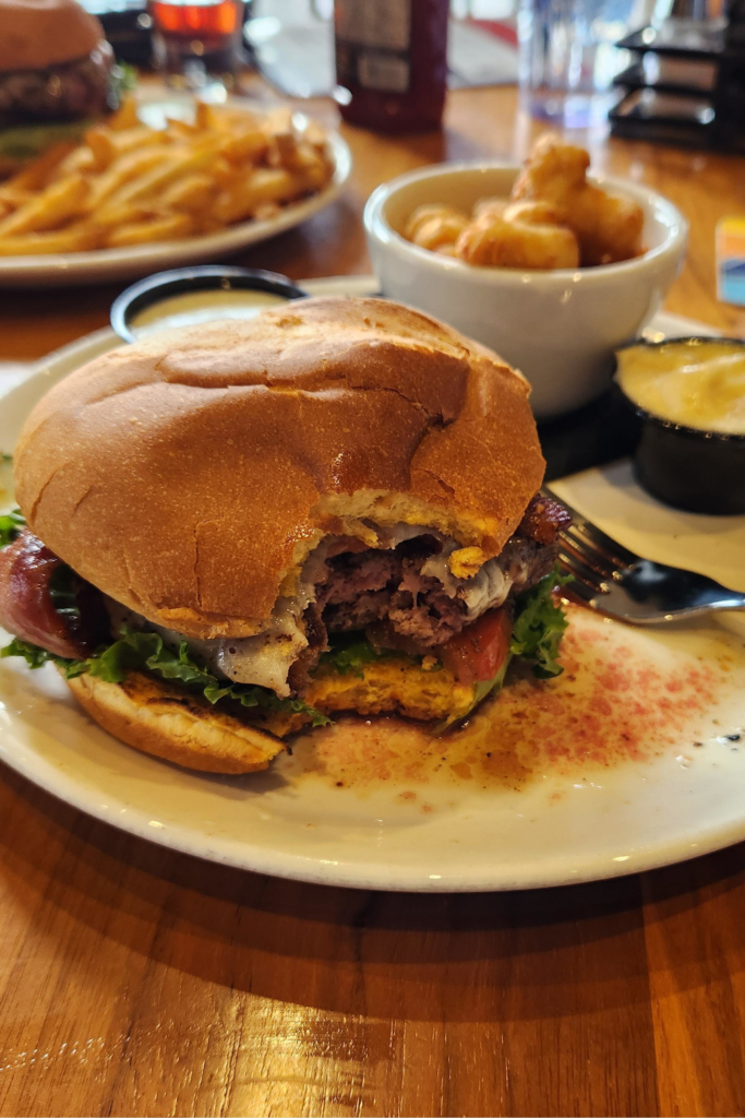 Close-up of bacon cheeseburger and cheese curds at Toppling Goliath Brewing