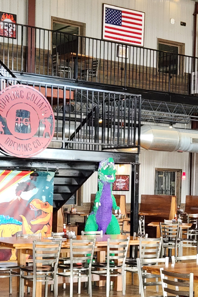 Interior seating area and LEGO dinosaur statue at Toppling Goliath Brewing Co