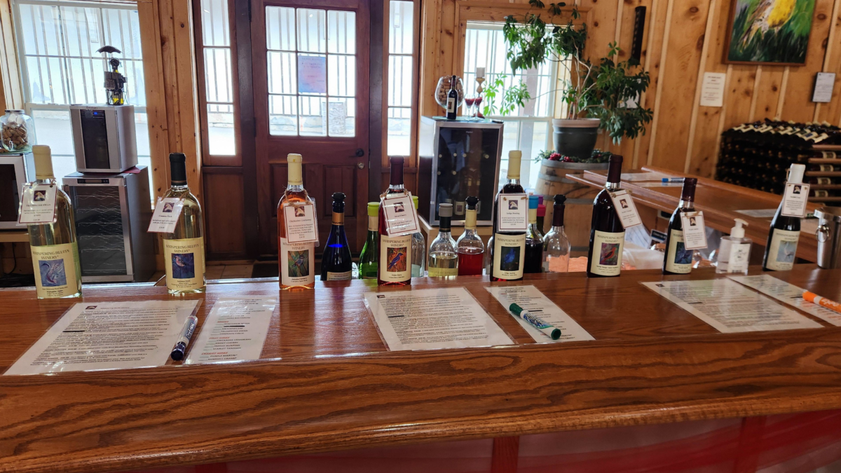 wine tasting bar at Whispering Bluffs Winery with bottles lined up in Potosi WI. Wisconsin winery Mississippi River