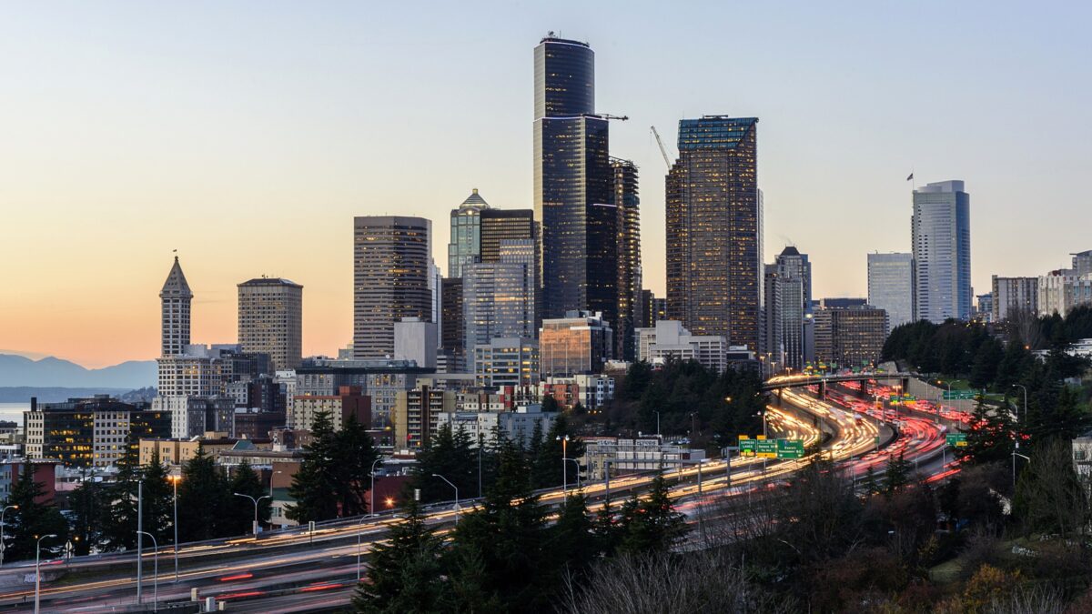 Downtown Seattle skyline at sunset with Interstate 5 traffic leading into the city.