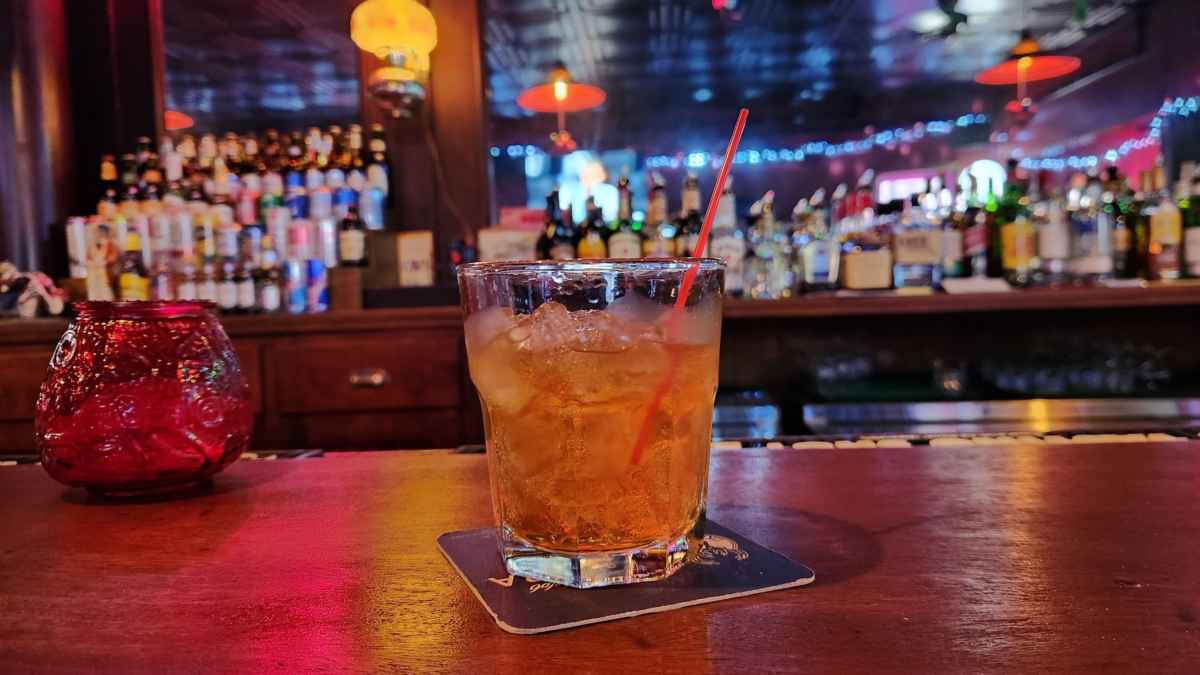 Cocktail on the bar at Elm Tree Bar in Cassville WI with bottles and tavern atmosphere in the background.