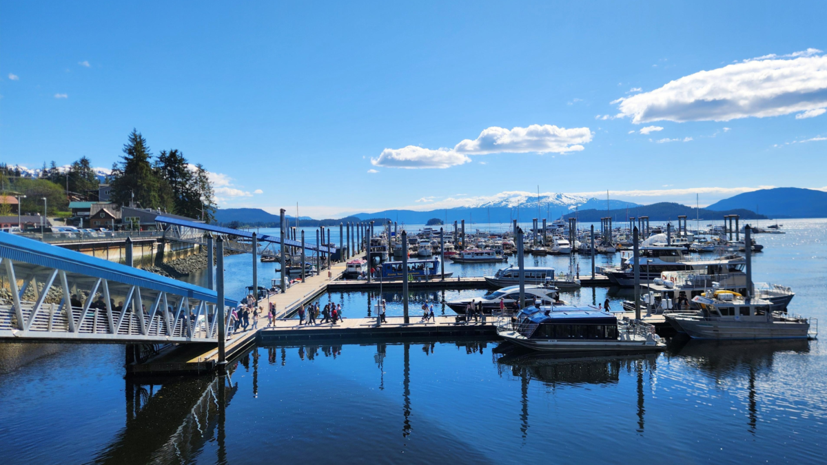 Auke Bay Marina near Juneau Alaska with boats docked at the harbor and snow-capped mountains in the distance