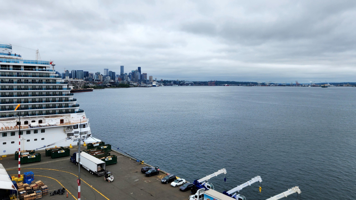 Cruise ship docked at Seattle Pier 91 with the downtown Seattle skyline across Elliott Bay.