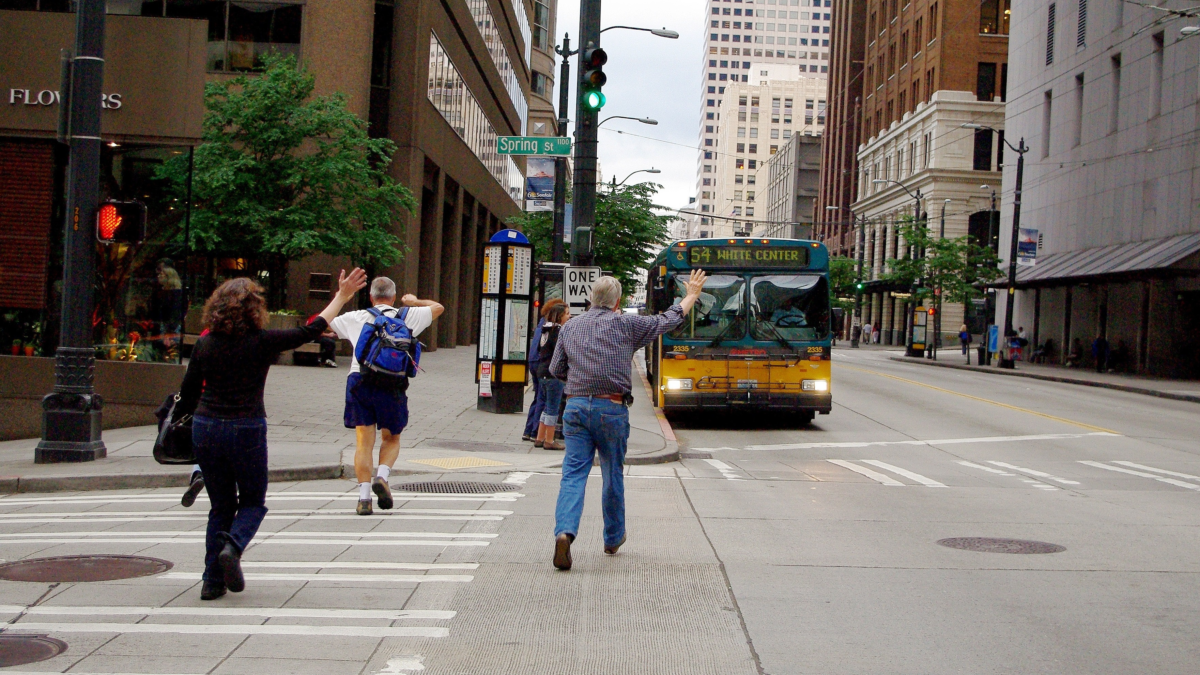 Seattle Metro bus approaching passengers waiting to board in downtown Seattle.