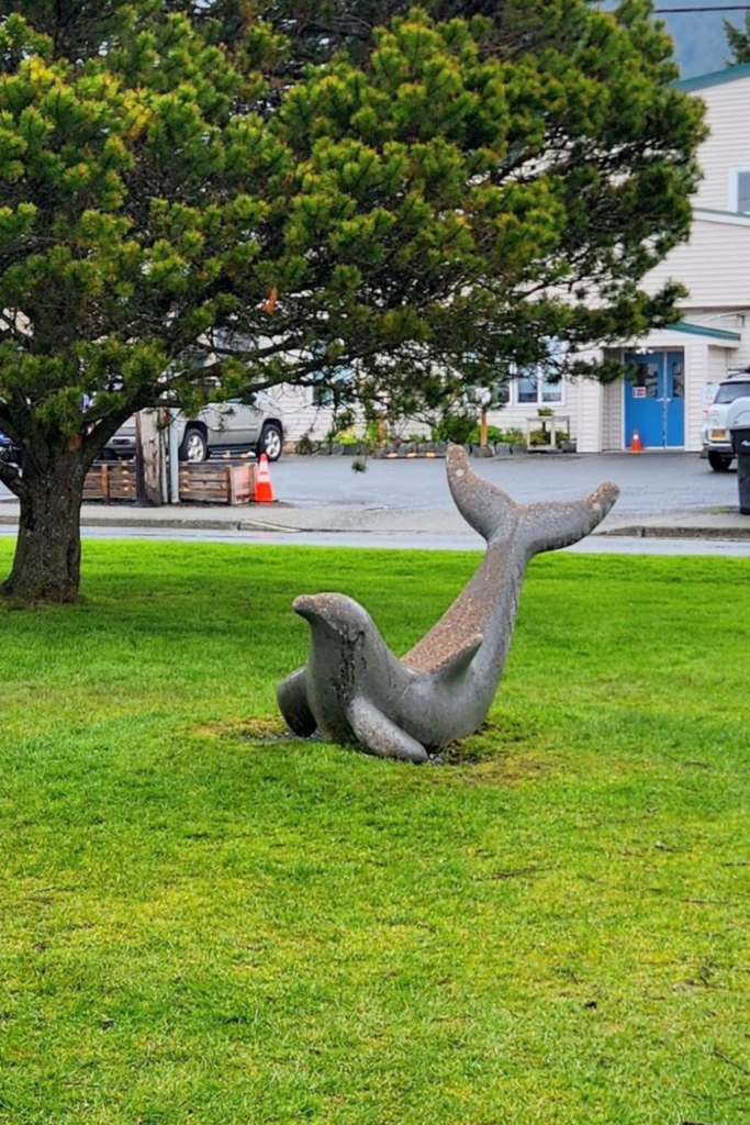 Marine animal sculpture with an upright tail at Crescent Harbor Park in Sitka, Alaska.