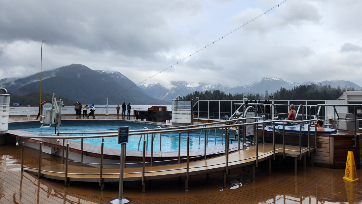 Cruise ship Lido Deck pool overlooking the mountains and water near Sitka, Alaska.