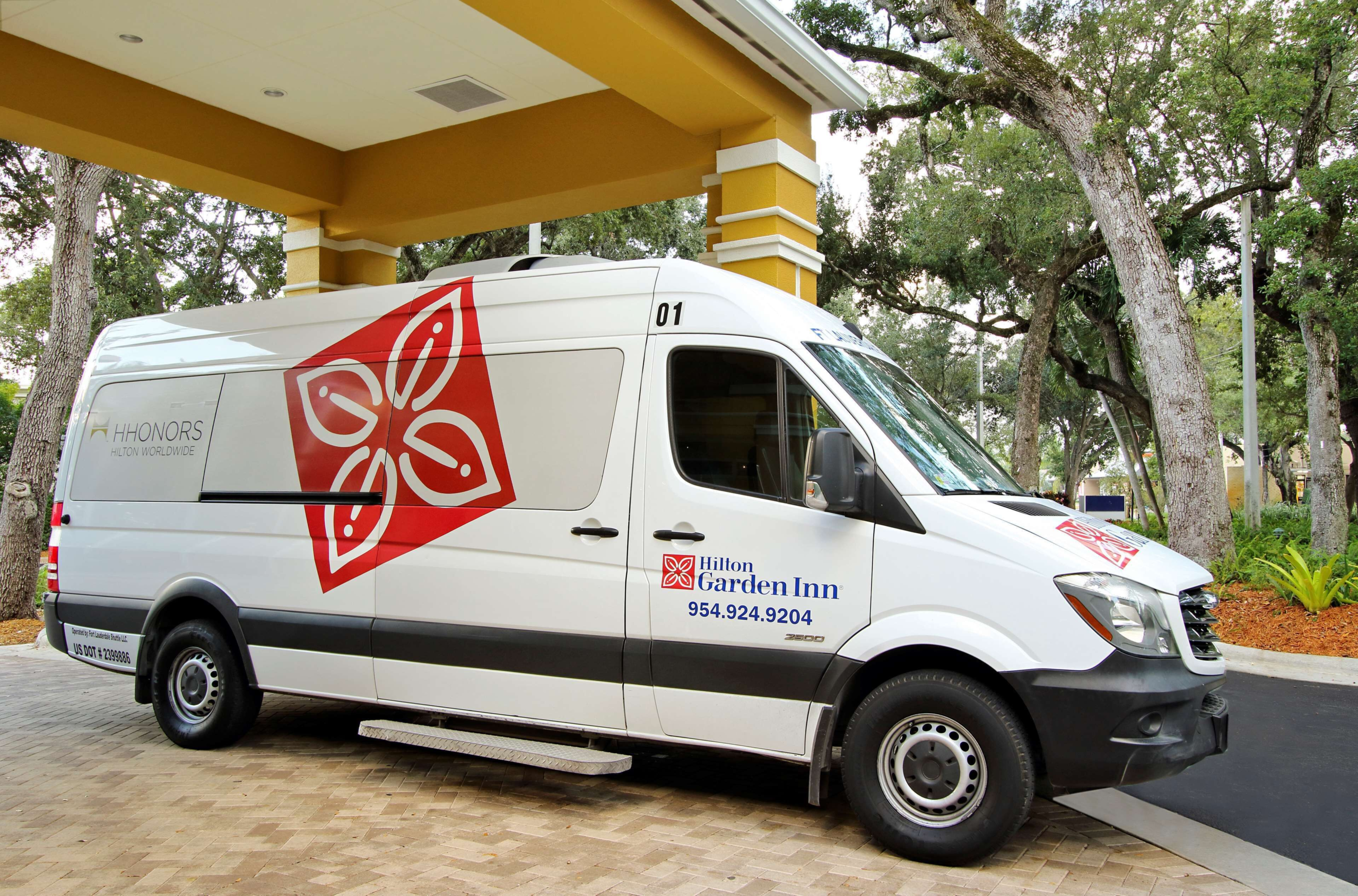 Hilton Garden Inn Fort Lauderdale Airport shuttle van parked outside the hotel
