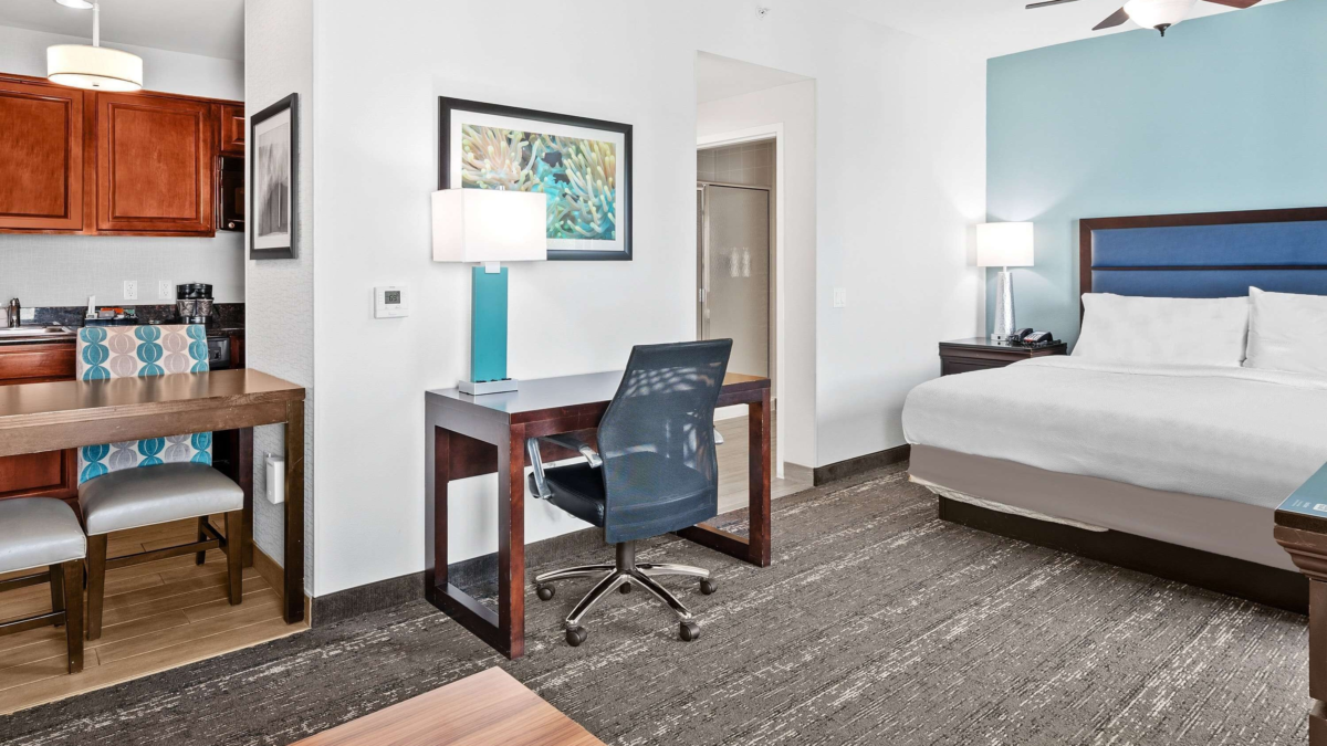 Homewood Suites Fort Lauderdale Airport suite with bed, kitchen, dining area, and workspace