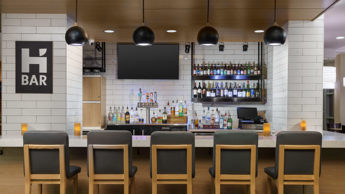 H Bar at Hyatt House Fort Lauderdale Airport with bar seating, televisions, beer taps, and full-service counter