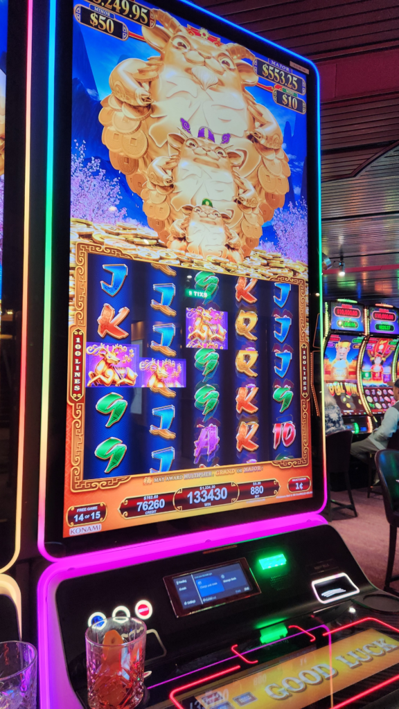 Colorful slot machine inside a cruise ship casino showing a Good Luck screen