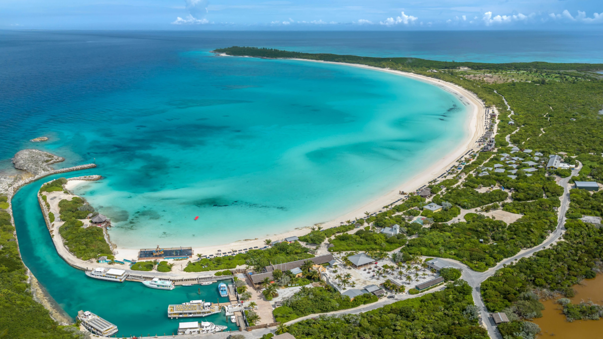 Aerial view of a tropical beach with turquoise water and a cruise pier