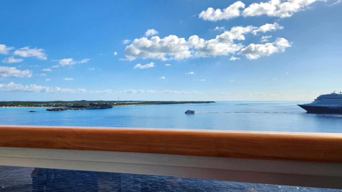 Tender boat traveling between a Holland America cruise ship and Half Moon Cay in the Bahamas, photographed from a cruise ship balcony.